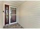 A close-up of the front entry, highlighting the storm door and patterned stone tiling at 26608 Racquet Cir, Leesburg, FL 34748