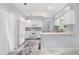 Efficient kitchen with white cabinets, appliances, and a pass-through counter at 26608 Racquet Cir, Leesburg, FL 34748