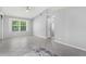Open living room with a ceiling fan, neutral paint, and a large window for natural light at 26608 Racquet Cir, Leesburg, FL 34748