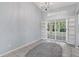 Bright living room featuring sliding glass doors, built-in shelving, and tile flooring at 26608 Racquet Cir, Leesburg, FL 34748