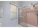 Bathroom shower with sliding glass door and pink tile at 26608 Racquet Cir, Leesburg, FL 34748