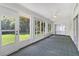 A sunroom with many large windows and ceiling fan, with a view of the backyard at 26608 Racquet Cir, Leesburg, FL 34748