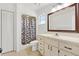 The bathroom has drawers and cabinets with a shower with patterned shower curtain at 2845 County Road 523, Wildwood, FL 34785