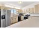 Well-lit kitchen with stainless steel refrigerator, and an adjacent counter offering open floor plan at 2845 County Road 523, Wildwood, FL 34785