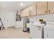 Convenient laundry room with cabinetry, utility sink and included washer and dryer at 2845 County Road 523, Wildwood, FL 34785