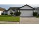 Charming single-story home featuring a well-manicured lawn and attached two-car garage at 3041 Bloomsbury Dr, Kissimmee, FL 34747