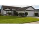 This single-story home features a well-manicured lawn and a two-car garage with concrete driveway at 3041 Bloomsbury Dr, Kissimmee, FL 34747