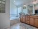 Bathroom featuring a soaking tub and a double sink vanity at 3136 Vandenberg Ct, The Villages, FL 32163