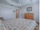 Cozy bedroom featuring a ceiling fan, wood floors, and closet at 3136 Vandenberg Ct, The Villages, FL 32163