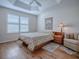 Bright bedroom with a ceiling fan, wood floors, and a comfortable chair at 3136 Vandenberg Ct, The Villages, FL 32163