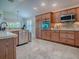 Well-lit kitchen boasts updated stainless steel appliances and custom wood cabinets, perfect for home cooking at 3136 Vandenberg Ct, The Villages, FL 32163