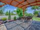 Enjoy outdoor dining on this patio with a pergola, brick pavers, and lush landscaping at 3136 Vandenberg Ct, The Villages, FL 32163