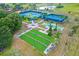 Overhead view showcasing the tennis court, bocce ball, and shuffleboard courts, all set within lush landscaping at 3205 Sonesta Ct # B, Clermont, FL 34711