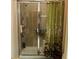 Glass-enclosed shower with tile surround, rainfall shower head, and convenient shelving at 3205 Sonesta Ct # B, Clermont, FL 34711