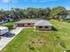 Aerial view of the home featuring a well-manicured front yard and lengthy driveway at 3380 Blossom St, Kissimmee, FL 34746