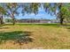 The sprawling backyard features a screened-in pool, mature trees, and luscious green lawn at 3380 Blossom St, Kissimmee, FL 34746