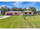 Charming brick home featuring an attached garage, lush lawn, and mature trees at 3380 Blossom St, Kissimmee, FL 34746