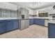 Renovated kitchen featuring stainless steel appliances, blue lower cabinets, and stylish backsplash at 3380 Blossom St, Kissimmee, FL 34746