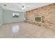 Living room features a brick accent wall with a fireplace and tile flooring at 3380 Blossom St, Kissimmee, FL 34746