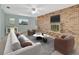 Cozy living room features a brick accent wall with a fireplace, neutral paint, and tile flooring at 3380 Blossom St, Kissimmee, FL 34746