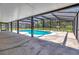 An open patio with a screened-in pool overlooking a lush backyard at 3380 Blossom St, Kissimmee, FL 34746