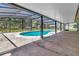 A view of a screened-in pool with a concrete patio and access to the backyard at 3380 Blossom St, Kissimmee, FL 34746