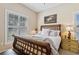 Cozy bedroom featuring neutral paint, a wooden bed frame, and plantation shutters for added privacy at 34021 Park Ln, Leesburg, FL 34788