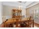 Bright dining room with wood table, chairs, china cabinet, hardwood floors and decorative chandelier at 34021 Park Ln, Leesburg, FL 34788