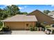 Exterior view of a home's garage, featuring a tan exterior and well-maintained surroundings at 34021 Park Ln, Leesburg, FL 34788