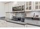 Modern kitchen with a microwave, black stove top, and white cabinets at 34021 Park Ln, Leesburg, FL 34788