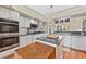 Open kitchen features an island, white cabinetry, and modern appliances at 34021 Park Ln, Leesburg, FL 34788