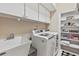 Convenient laundry room equipped with washer, dryer, sink, and ample storage at 34021 Park Ln, Leesburg, FL 34788