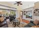Open living room features hardwood floors, a built-in media center, and sliding glass doors to the sunroom at 34021 Park Ln, Leesburg, FL 34788