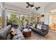 Bright sunroom featuring brick flooring, large windows, and comfortable seating with a view of the backyard at 34021 Park Ln, Leesburg, FL 34788