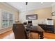 A well-lit home office space with a large desk, comfortable chair and ample natural light at 34021 Park Ln, Leesburg, FL 34788