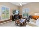 Cozy sitting room with natural light, comfortable seating, and a large TV at 34021 Park Ln, Leesburg, FL 34788