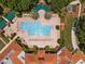 Stunning aerial view of the community pool, spa, and surrounding lush landscaping and roof tops at 3706 Doune Way, Clermont, FL 34711