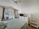 Bedroom featuring plank floors, a ceiling fan, and a large window at 3706 Doune Way, Clermont, FL 34711