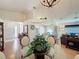 Open-concept dining area with a glass-top table, flowing into the modern kitchen and living room at 3706 Doune Way, Clermont, FL 34711