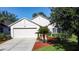 Charming home featuring a well-manicured lawn, mature trees, and a two-car garage at 3706 Doune Way, Clermont, FL 34711