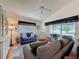 Comfortable living room featuring hardwood floors, a ceiling fan, and plush couches with golf course views at 3706 Doune Way, Clermont, FL 34711