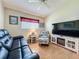 Comfortable living room with a sleek entertainment center, leather sofa, and a cozy armchair at 3706 Doune Way, Clermont, FL 34711