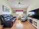 Comfortable living room with a sleek entertainment center, leather sofa, and a cozy armchair at 3706 Doune Way, Clermont, FL 34711
