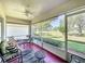 Relaxing screened patio features a ceiling fan, comfortable seating and a lovely view of the lush backyard at 3706 Doune Way, Clermont, FL 34711
