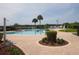 Inviting swimming pool with a brick paver deck and a small seating area surrounded by lush landscaping at 3706 Doune Way, Clermont, FL 34711