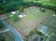 Aerial view of property showcasing large lot with multiple structures, road, and grassy areas at 37149 Grays Airport, Lady Lake, FL 32159