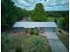 Aerial view of a one-story home with lush lawn, metal roof, and a long driveway at 37149 Grays Airport, Lady Lake, FL 32159