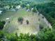 Large, partially cleared land with scattered trees, surrounded by a mix of greenery and residential areas at 37149 Grays Airport, Lady Lake, FL 32159