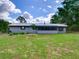 Fenced backyard with screen porch, freshly mowed lawn and mature trees at 37149 Grays Airport, Lady Lake, FL 32159