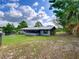 Exterior of house featuring a screened in porch, trees, and a large grassy area at 37149 Grays Airport, Lady Lake, FL 32159